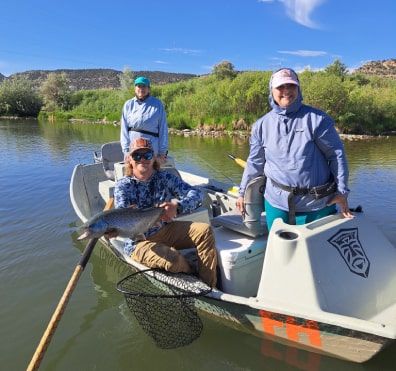 Guide and customers in drift boat 396