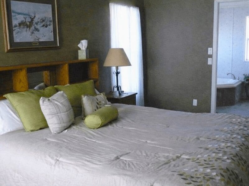 White bed with green throw pillows